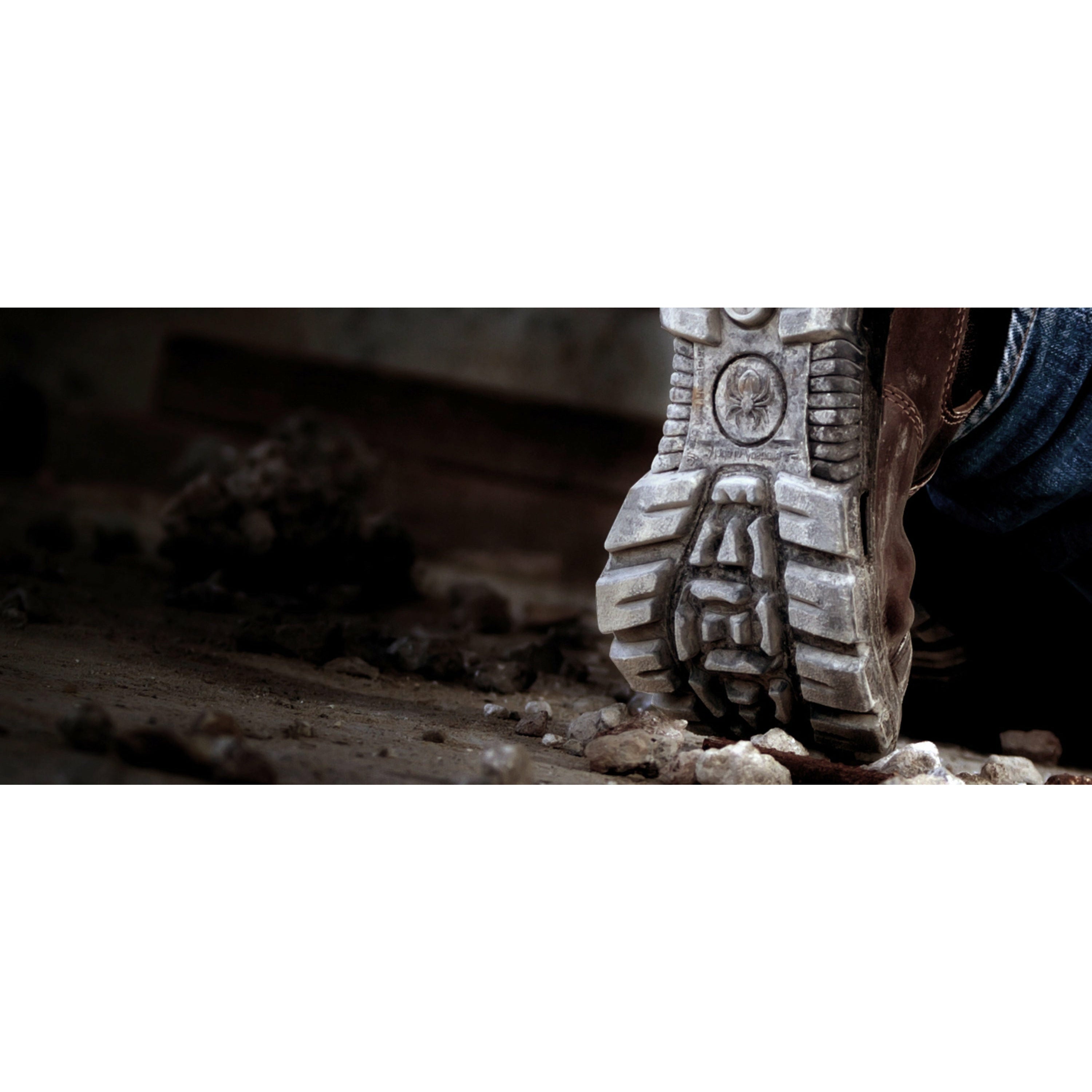 Close-up of a boot stepping onto a rough surface