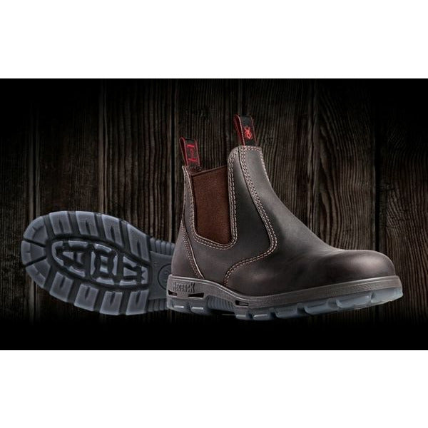 Brown leather boot with a visible brand logo on a dark wooden background