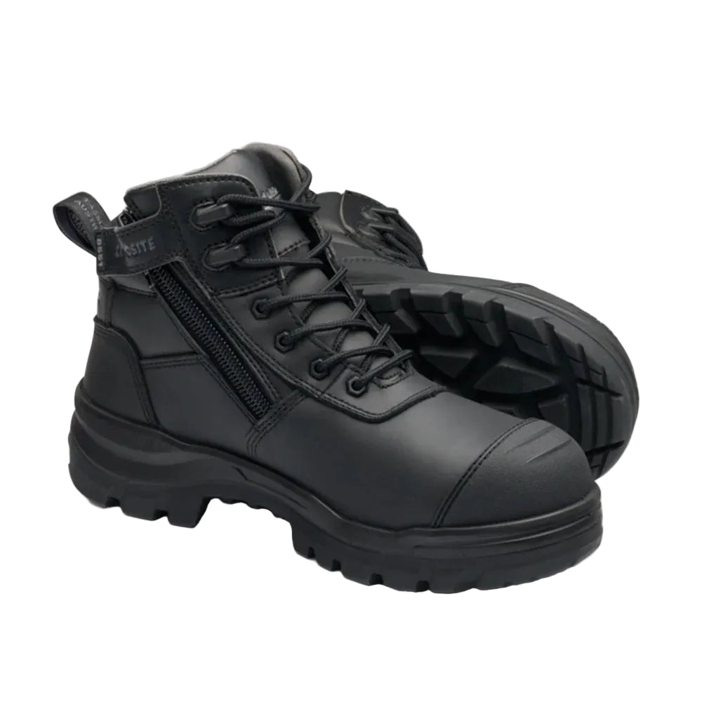 A pair of black high-top work boots with a side zipper, lace-up front, and rugged sole, shown on a light beige background.